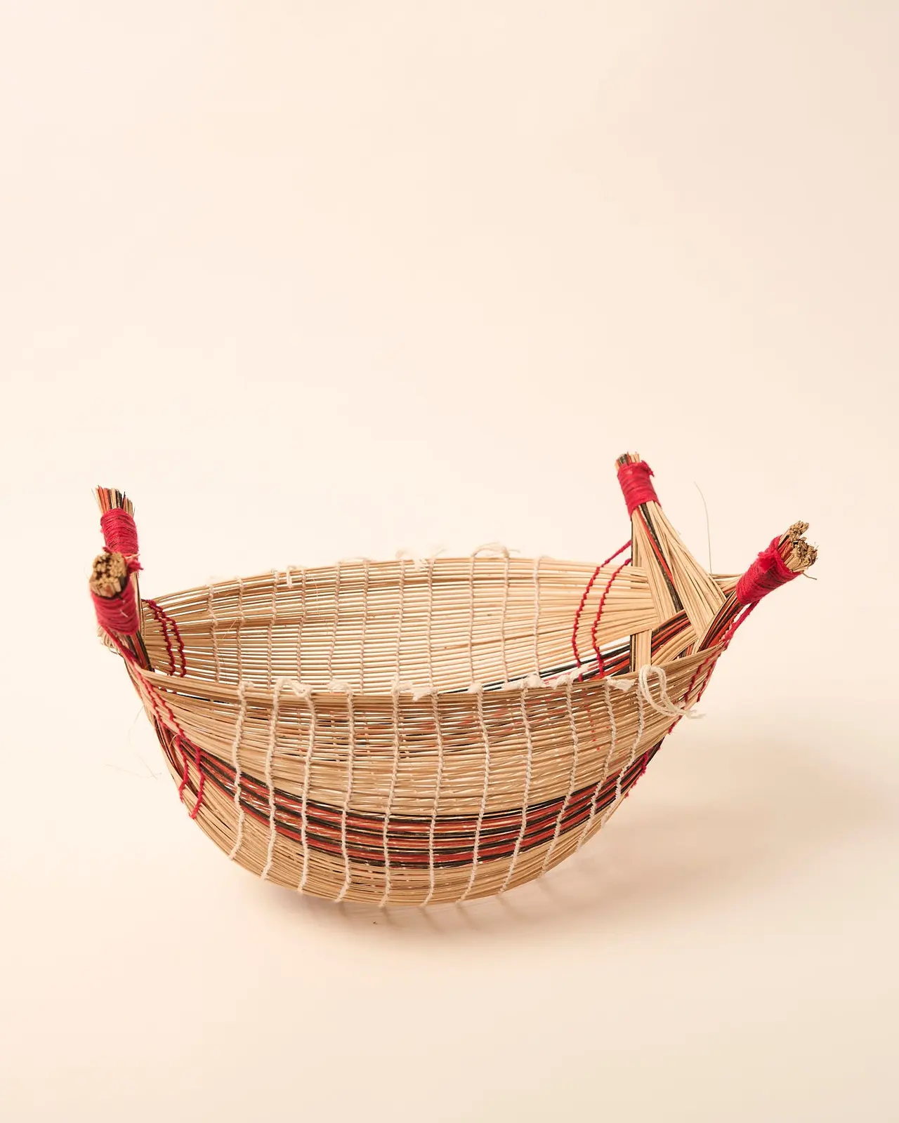 Interior do Cesto Mehinako, com trama aberta e quatro pontas amarradas com fio vermelho.